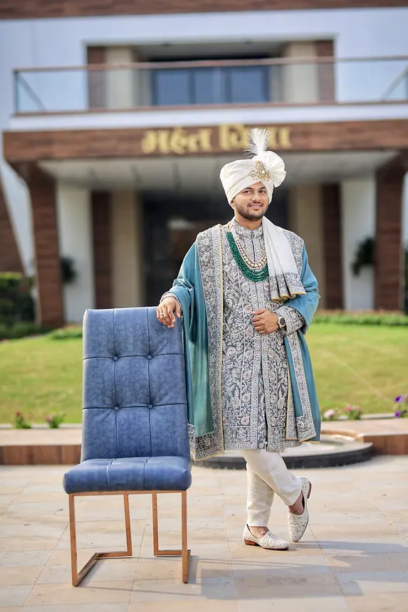 Groom in teal shawl posing with a chair