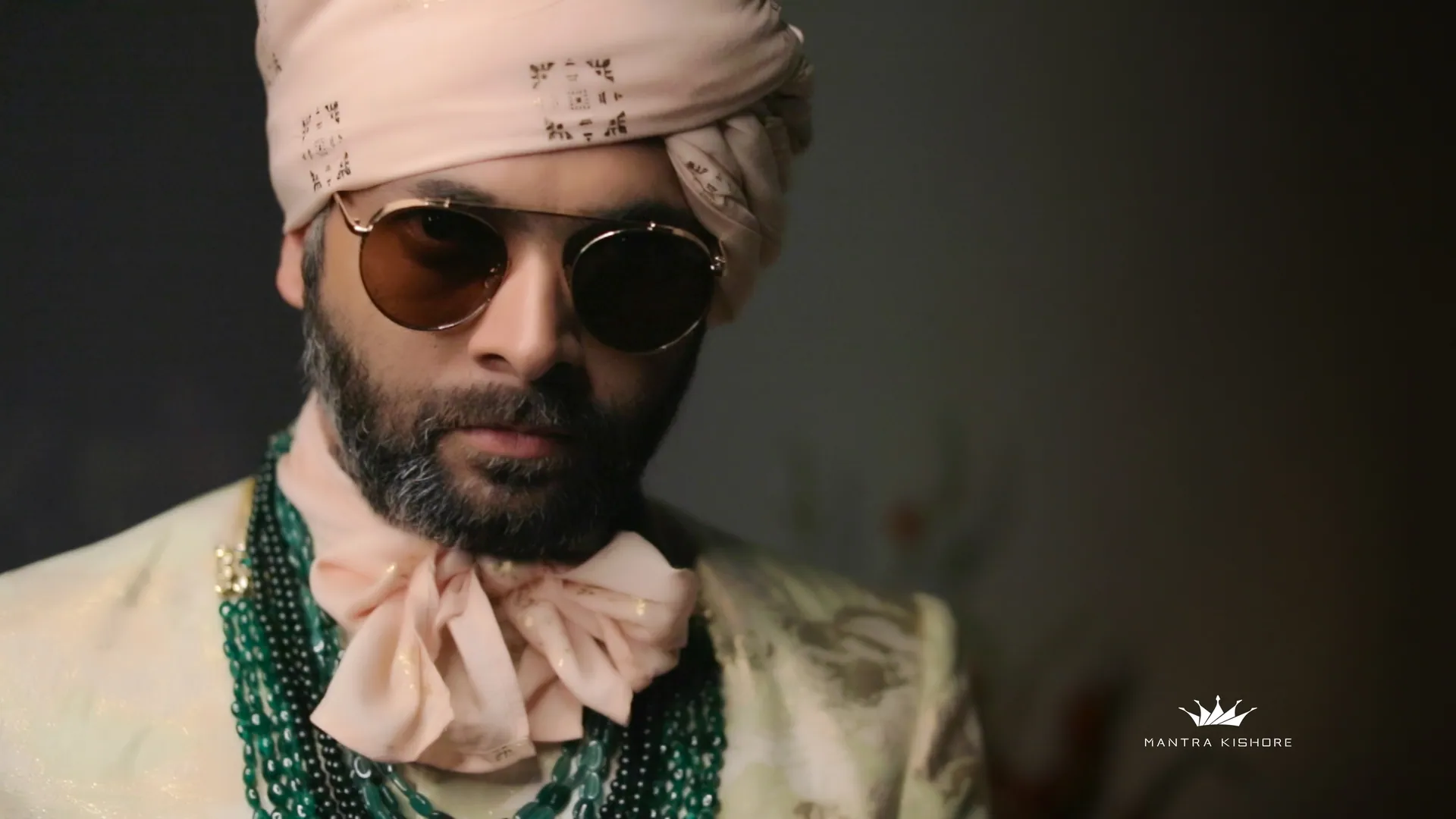 Close-up of a styled groom in blush turban