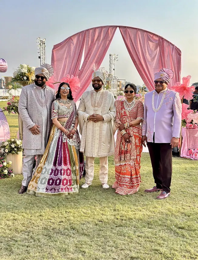 Groom and family under a pink canopy