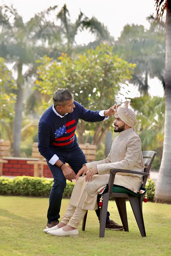 Kishore adjusting the groom's safa outdoors