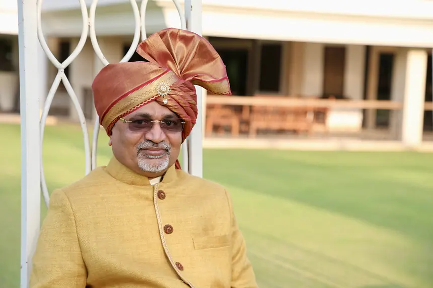 Groom's father in rust safa and mustard bandhgala